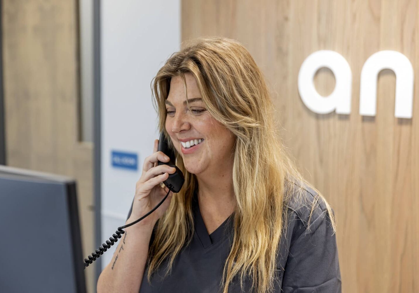 The receptionist at Livewell Animal Hospital of Edmond answering the phone happily